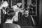 Young handsome barber making haircut for attractive man in barbershop