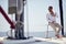 A young handsome barefoot male model is in a good mood while enjoying a photo shooting on a yacht on the seaside. Summer, sea,