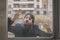 Young handsome bearded man posing behind a glass