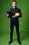 Young handsome businessman with hardhat against green background