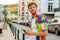 Young handsome calm redhead man in colorful shirt with phone