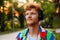 Young handsome calm redhead man in headphones looking aside