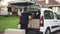 Young handsome Caucasian delivery man putting boxes in van delivering shipment. Male post office worker Courier concept