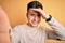 Young handsome caucasian man talking a selfie picture over yellow isolated background stressed with hand on head, shocked with