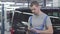 Young handsome Caucasian man in workwear standing with tablet at the background of black car. Serious male auto mechanic