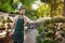 Young handsome cheerful gardener smiling, watering, taking care of plants.