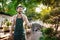 Young handsome cheerful gardener smiling, watering, taking care of plants.