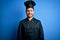 Young handsome chef man with beard wearing cooker uniform and hat over blue background with a happy and cool smile on face