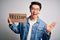 Young handsome chinese activist man protesting asking for freedom holding poster very happy and excited, winner expression