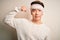 Young handsome chinese man injured for accident wearing bandage and strips on head Strong person showing arm muscle, confident and