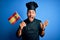 Young handsome cooker man with beard wearing uniform holding spain spanish flag very happy and excited, winner expression