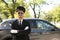 Young handsome driver standing near luxury car.