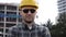 Young handsome engineer man wearing safety helmet in sunglasses making a look to camera.