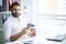 Young handsome entrepreneur sitting at desk and using laptop in