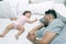 Young handsome father tired sleeping withone year baby girl. Bearded dad sleeps with baby in bed. Little newborn child in white