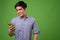 Young handsome Filipino man against green background