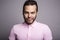 Young handsome fitness man in pink shirt, studio shot.