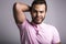 Young handsome fitness man in pink shirt, studio shot.