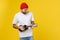 Young handsome guitar player. Studio shot on yellow background.