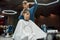 Young handsome guy getting new modern haircut. Professional barber girl working with client in barber shop or beauty