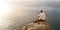 Young handsome guy sitting on rock above ocean