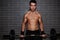 Young handsome guy weightlifter lifting barbell exercising chest and biceps muscle at gym