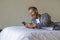 Young handsome and happy man at home using internet mobile phone on bed smiling cheerful and satisfied feeling relaxed dating