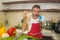 Young handsome and happy man in red apron holding cooking pot smiling cheerful preparing yummy stew smelling delicious aroma in