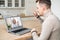 Young handsome hipster man waving at laptop