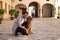 young handsome Hispanic man with his brown golden retriever dog, they are crouched down looking at the same place. Concept pets,