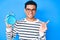 Young handsome hispanic man holding alarm clock smiling happy pointing with hand and finger to the side