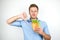 Young handsome hungry man holding fresh sandwich with salad leaf showing dislike sign on  white background