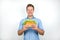 Young handsome hungry man looks hungry and happy holding fresh sandwich with salad on  white background