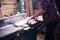 Young handsome joiner working with wood in his carpentry workshop