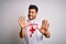 Young handsome lifeguard man with beard wearing t-shirt with red cross and whistle afraid and terrified with fear expression stop