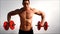 Young handsome male bodybuilder training shoulders with dumbbells