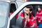 young handsome male paramedic standing near ambulance and talking