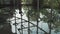 A young handsome man in an architect or lawyer suit walks around a modern office. Reflection in a glass table.