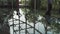 A young handsome man in an architect or lawyer suit walks around a modern office. Reflection in a glass table.