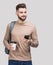 Young handsome man with backpack holding smart phone and coffee. Smiling student or businessman portrait.