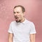 Young handsome man with beard sneezing, studio portrait