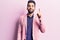 Young handsome man with beard wearing elegant jacket pointing finger up with successful idea