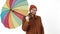 Young handsome man with beard wearing raincoat for rainy day holding colorful rainbow umbrella, spinning it around, and
