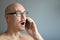 Young handsome man in black glasses is talking on the phone, smiling. Closeup portrait of a man. Manager, office worker, talking