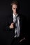 Young handsome man in a business suit and a white shirt and tie in formal style in the Studio on a black background