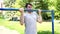 A young handsome man in casual clothes jokingly is doing pull up exercise on horizontal bar. The concept of humor, jokes