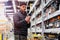 Young handsome man choosing wine in supermarket. Matter of wine choice