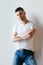 Young handsome man with crossed arms posing on white background