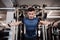 A young handsome man doing strength workout exercise in gym.