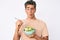 Young handsome man eating salad making fish face with mouth and squinting eyes, crazy and comical